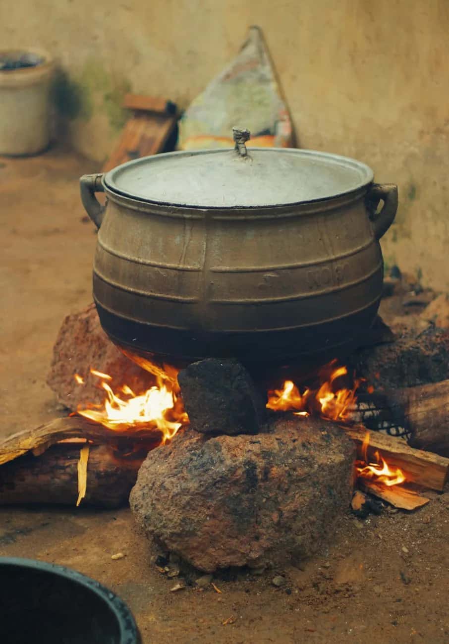 Marmite posée sur un feu de bois