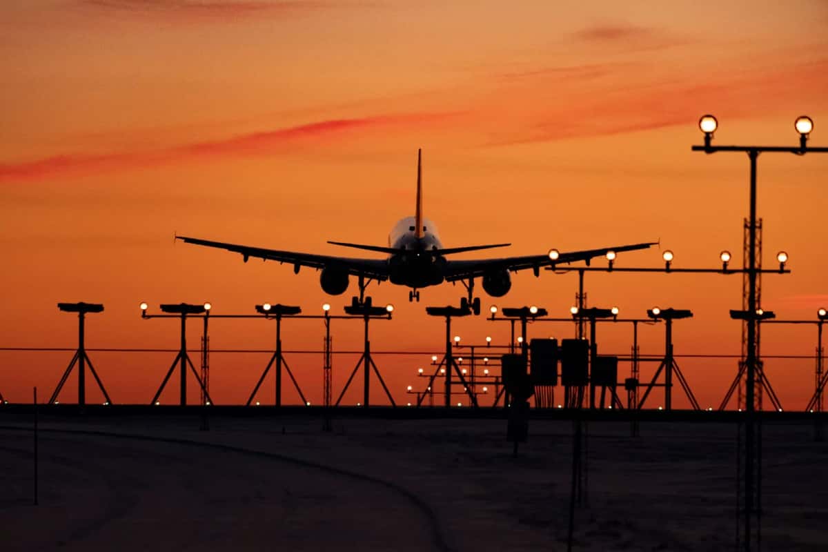 Avion de ligne à l'atterrissage au crépuscule au-dessus des feux de piste