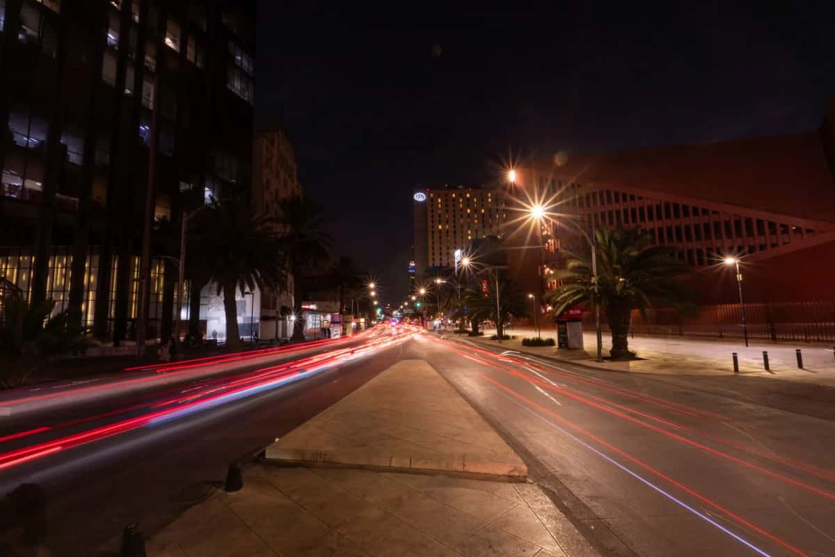 Avenue de nuit et traînées lumineuses des phares