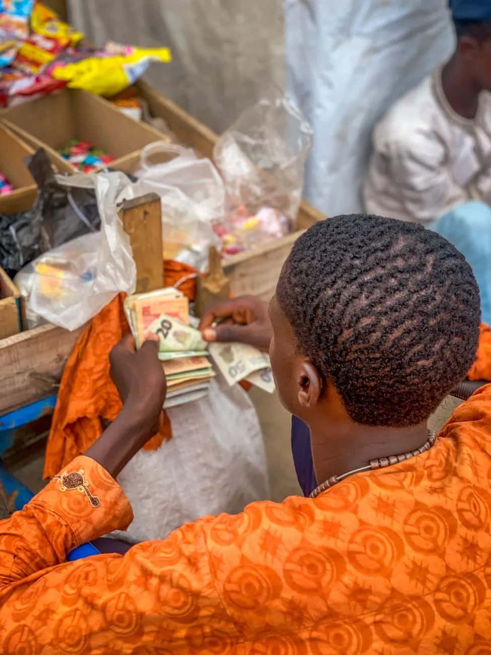 Échange de billets sur un marché en Afrique de l'Ouest