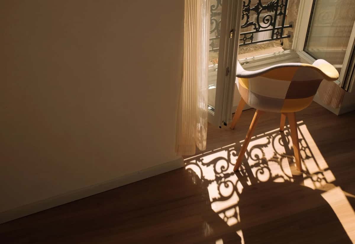 Intérieur lumineux traversé par l'ombre d'une ferronnerie