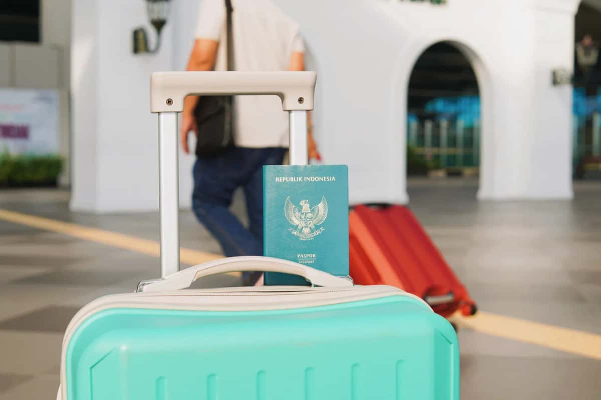 Valise et passeport dans une aérogare au moment du départ