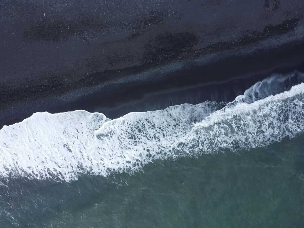 Ligne d'écume vue du ciel sur une longue plage