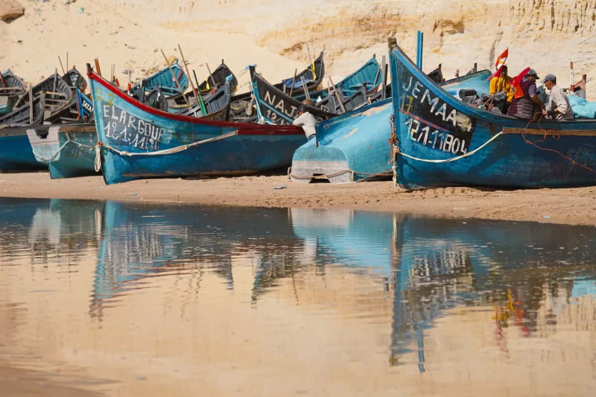Pirogues de pêche colorées alignées sur une plage du Sénégal