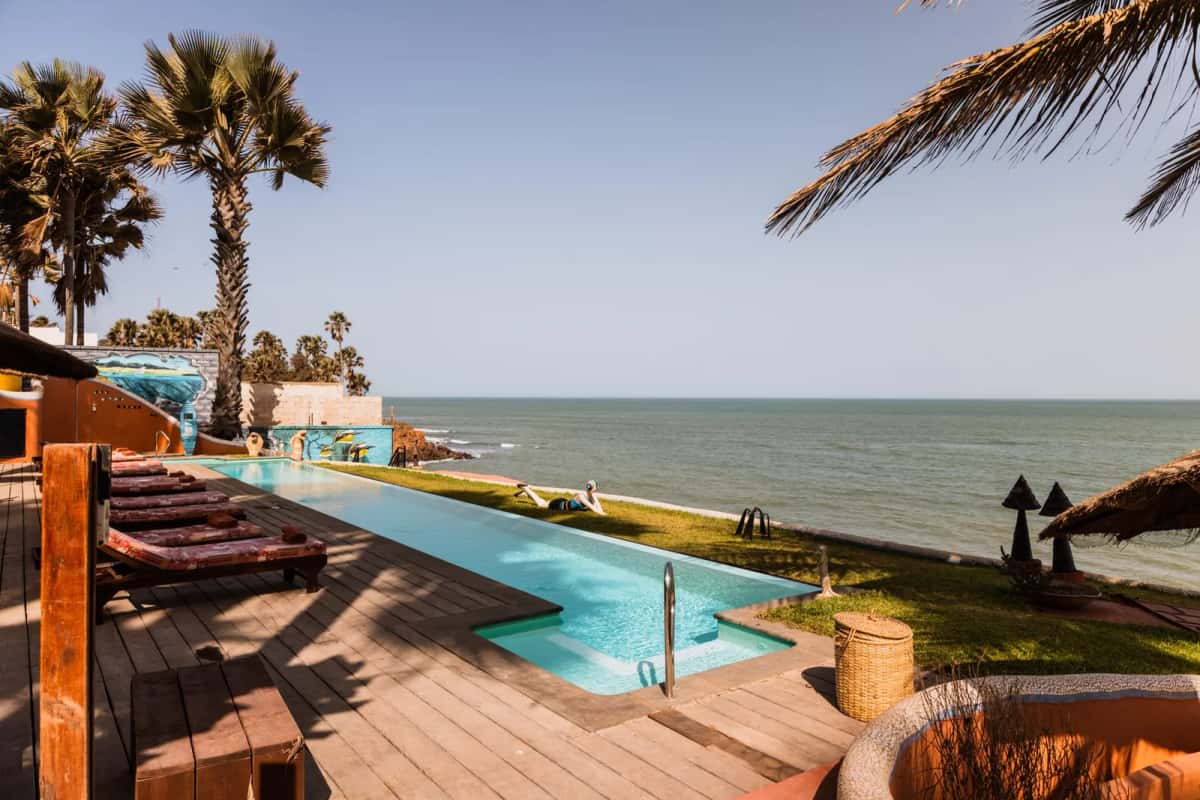 Piscine bordée de cocotiers face à la mer sur la Petite Côte à Saly