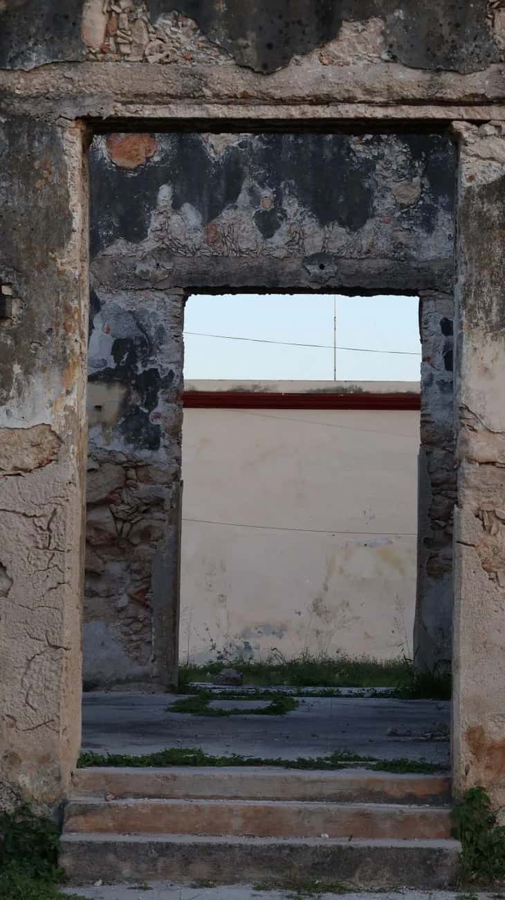 Ouverture dans un mur en ruine donnant sur la mer