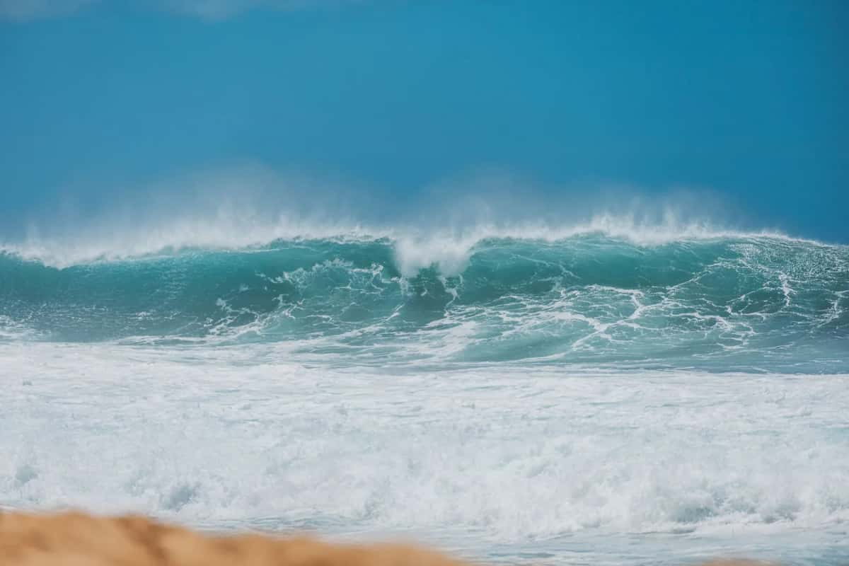 Vague déferlant sur une plage de sable